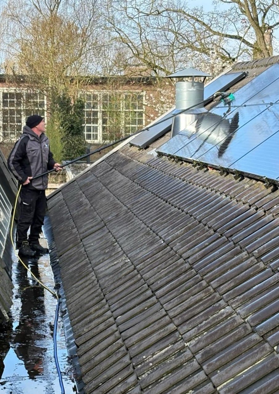 Zonnepanelen reinigen op schuin dak door gecertificeerde glazenwasser